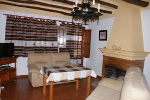 ein Wohnzimmer mit einem Sofa und einem Kamin in der Unterkunft Casa De La Ermita in Bubión