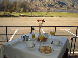 Ribadelago的住宿－Hotel Don Pepe Lago de Sanabria，一张桌子,上面放着两杯橙汁和面包