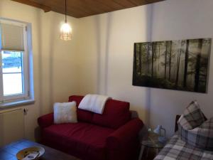 ein Wohnzimmer mit einem roten Sofa und einem Fenster in der Unterkunft Chez nous in Pfronten
