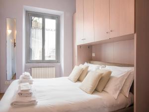 ミラノにあるeasyhomes - Porta Venezia Oberdanのベッドルーム1室(大きな白いベッド1台、タオル付)