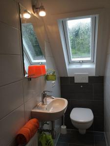 a bathroom with a sink and a toilet and a window at Messe Stuttgart Ferienwohnungen Kaiser in Ostfildern