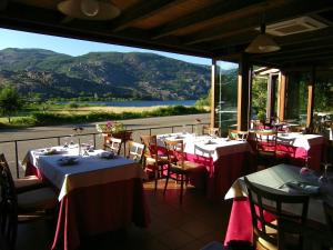 a restaurant with tables and chairs with a view of a mountain at Hotel Don Pepe Lago de Sanabria in Ribadelago