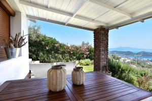 a wooden table with two vases on top of a patio at Agia Kali Villas in Skiathos Town