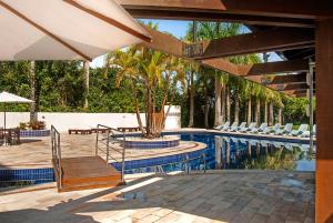 a patio with a pool and a table and chairs at Hotel Torres da Cachoeira in Florianópolis