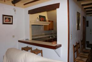 Casa De La Ermita في بوبيون: مطبخ مع موقد وسرير في الغرفة