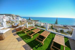 a balcony with chairs and a view of the ocean at Luz Beach Rooftop Penthouse in Luz