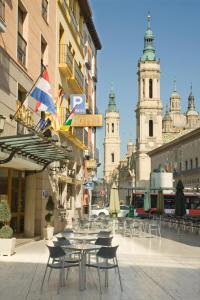 una calle de la ciudad con mesas, sillas y edificios en Hotel Tibur en Zaragoza