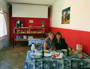 リャンサにあるAlberg Costa Bravaの二人の女が食べ物を持ってテーブルに座っている