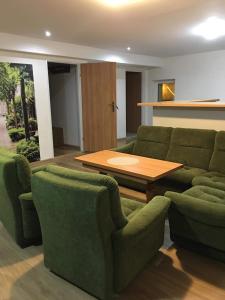 Wykroty的住宿－Gospodarstwo Agroturystyczne " GABRYSIA "，客厅配有绿色沙发和木桌