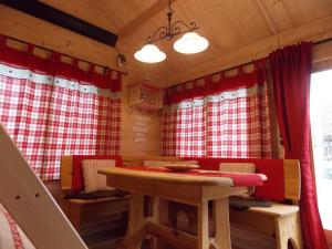 ein Esszimmer mit einem Tisch und roten Vorhängen in der Unterkunft Weiherhütte in Glan-Münchweiler
