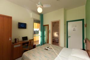 Un dormitorio con una cama y un escritorio con una computadora. en Hotel Florida, en Silvi Marina