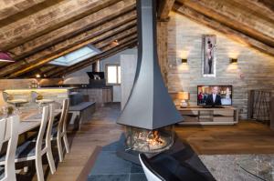 a fireplace in the middle of a living room with a table at Chalet Emilie in Courchevel