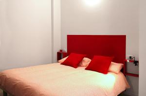 sypialnia z czerwonym zagłówkiem i łóżkiem z czerwonymi poduszkami w obiekcie La Casa Di Eva w Bolonii