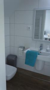 a white toilet sitting next to a sink in a bathroom at GästeHaus am Flughafen Düsseldorf in Düsseldorf