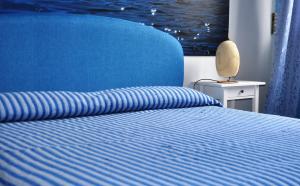a bedroom with a blue bed with a blue ocean at B&B Stella Marina in Acitrezza