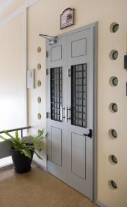 une porte blanche dans une pièce avec une plante dans l'établissement Loulé Coreto Hostel, à Loulé