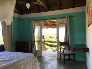 a bedroom with a bed and a sliding glass door at Recanto Praia do Forte - SC in São Francisco do Sul