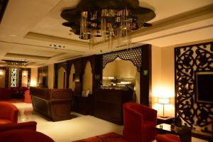 vestíbulo del hotel con espejo y sillas rojas en Home Inn Hotel Suites en Al Khobar
