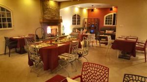 une salle à manger avec des tables, des chaises et une cheminée dans l'établissement L'échappée belle Benslimane, à Benslimane