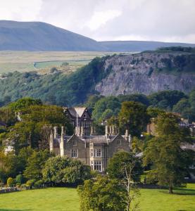 un viejo castillo en un campo en las colinas en Falcon Manor Hotel en Settle