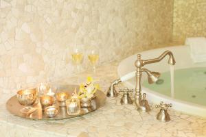 La salle de bains est pourvue d'un lavabo avec des bougies et des verres à vin. dans l'établissement Bad Bubendorf Design & Lifestyle Hotel, à Bubendorf