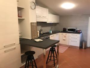 a kitchen with white cabinets and a black counter top at La Ghirlanda B&B in Arezzo