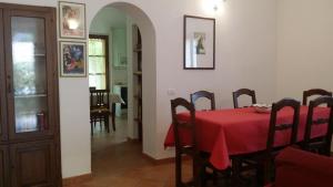 uma sala de jantar com uma mesa vermelha e cadeiras em Sunflower em San Quirico dʼOrcia