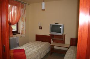 - une petite chambre avec un lit et une télévision dans l'établissement Villa Patio, à Patince