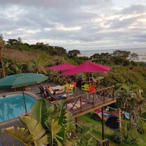 Tugela Mouth的住宿－Sensayuma Backpackers，一个带游泳池和粉红色遮阳伞的度假村