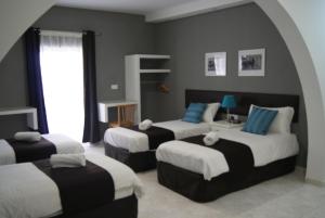 a hotel room with two beds and two couches at Buccaneers Boutique Guest House in St Paul's Bay