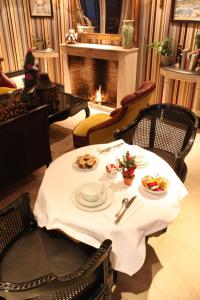 a table with plates of food and a fireplace at Hôtel du Romancier in Paris