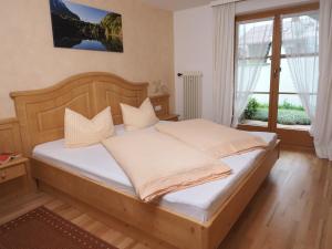ein Schlafzimmer mit einem Holzbett mit weißen Kissen in der Unterkunft Haus Antonius in Oberstdorf