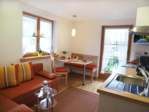 a kitchen and living room with a couch and a table at Haus Antonius - Bergbahnticket von Mai bis November inklusive! in Oberstdorf