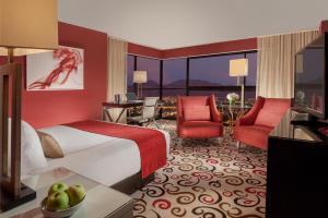 a hotel room with a bed and a desk and chairs at Downtown Grand Hotel & Casino in Las Vegas
