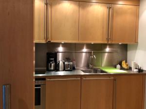 a kitchen with wooden cabinets and a sink at Suite im Sony Center am Potsdamer Platz in Berlin