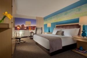 a hotel room with a large bed and a desk at Downtown Grand Hotel & Casino in Las Vegas
