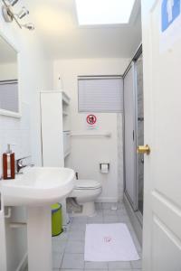 uma casa de banho branca com um lavatório e um WC em Casa Suiza em Santa Cruz