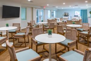 a room with tables and chairs and a flat screen tv at The Palms Oceanfront Hotel in Isle of Palms