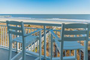 2 sillas sentadas en un balcón con vistas a la playa en The Palms Oceanfront Hotel, en Isle of Palms