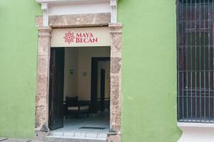 un bâtiment vert avec un panneau indiquant le comportement maxa dans l'établissement Hotel Maya Becan, à Campeche