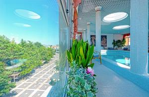 un balcón de un edificio con piscina y plantas en Hotel Aurora Terme, en Abano Terme