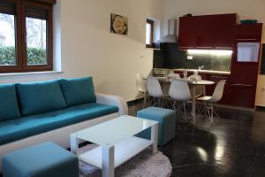 a living room with a blue couch and a table at Casa Rados Fazana in Fažana