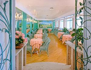 a dining room with pink tables and green chairs at Hotel Aurora Terme in Abano Terme