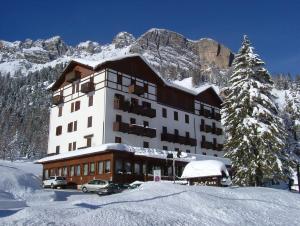 a large building in the snow with a mountain at Hotel Lavaredo in Misurina