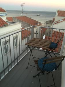 uma varanda com uma mesa e cadeiras e o oceano em Don Sebastiao em Sesimbra