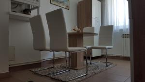a dining room with a table and four chairs at Apartmani Ana in Slatina