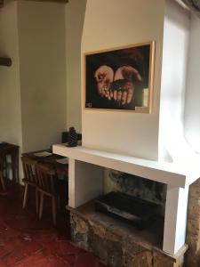 a fireplace in a room with a picture on the wall at Hotel Casitas Barro Iza Boyaca in Iza