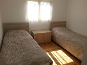 two beds in a small room with a window at Guest House ALUDA in Omalo