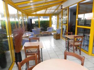a restaurant with tables and chairs and windows at Kyriad Chantilly in Chantilly +27 photos