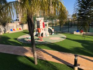 - une aire de jeux dans un parc avec un palmier dans l'établissement Bajo 2 del Edificio Lucerna III - Mil Palmeras, à Pilar de la Horadada